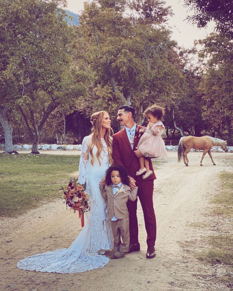 Boho bride with long half-up braided waves alongside her family