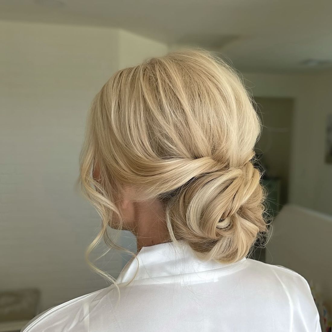 Sleek low bridal bun with a soft twist